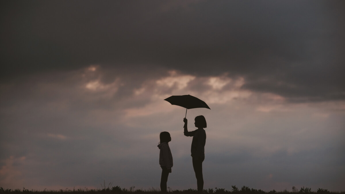 Etichette e stereotipi - Adulto con ombrello che protegge bambino dalla pioggia